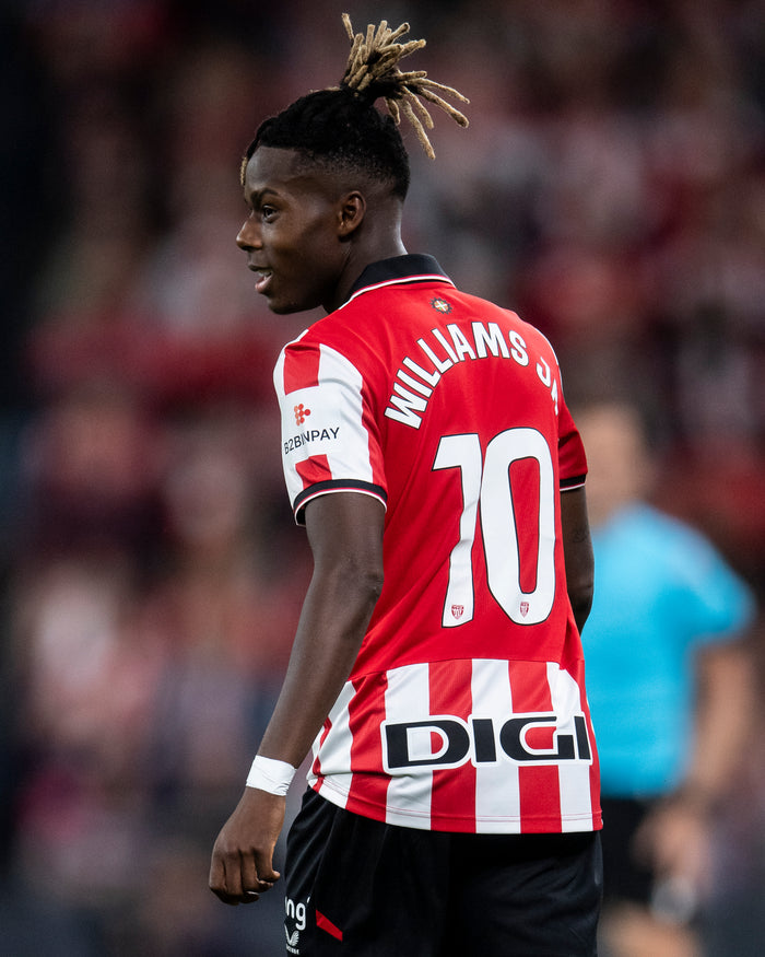 Soccer player in Athletic Club home shirt seen from behind with Williams 10 on red and white stripes