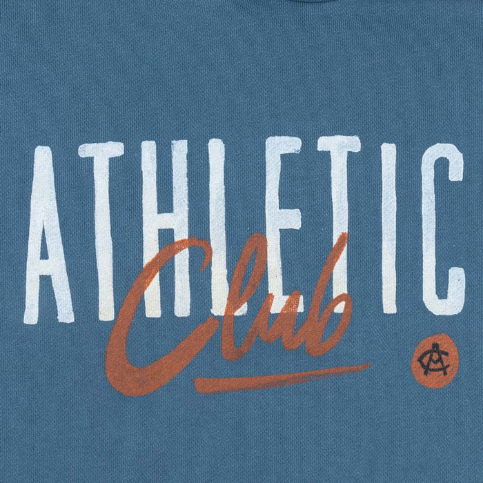 Close-up of chest graphic on blue hoodie showing white ATHLETIC text and orange script with a small circular emblem