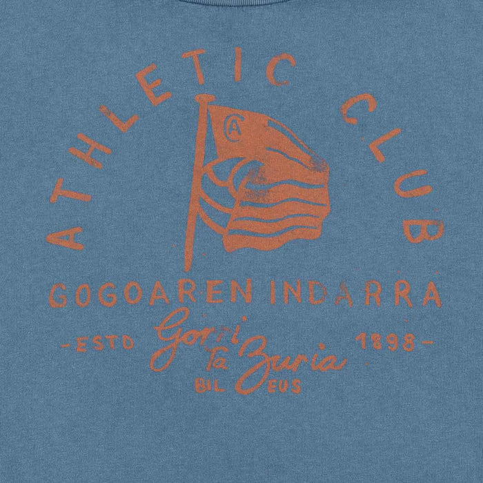 Close-up of orange graphic print on blue fabric featuring a flag and circular text.