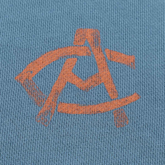 Close-up of orange AC logo on blue fabric of men's AC Collection Shorts