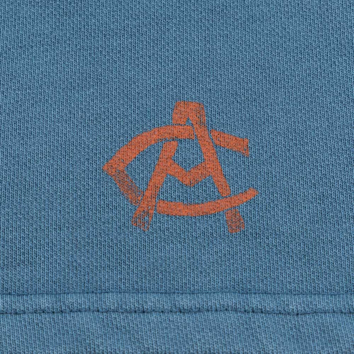 Close-up of blue fabric with an orange AC logo.