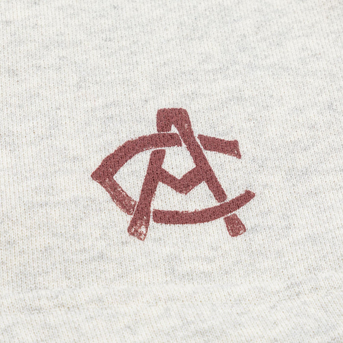 Close up of white heather fabric with a red stylized logo
