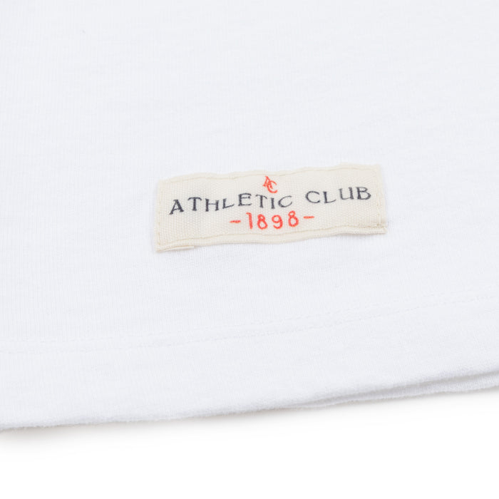 Close up of white fabric with cream patch reading ATHLETIC CLUB -1898-