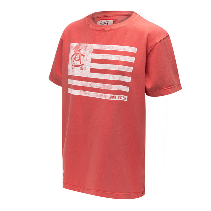Coral red Junior AC Collection Flag Tee with distressed white flag graphic across the chest
