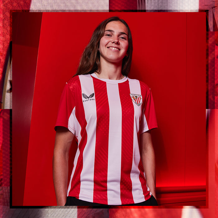 Woman models red and white striped home short sleeve shirt with club crest on the chest