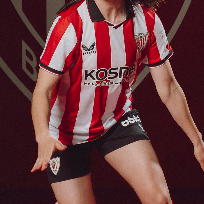 Athlete wearing red and white striped Athletic Club jersey in action with black shorts