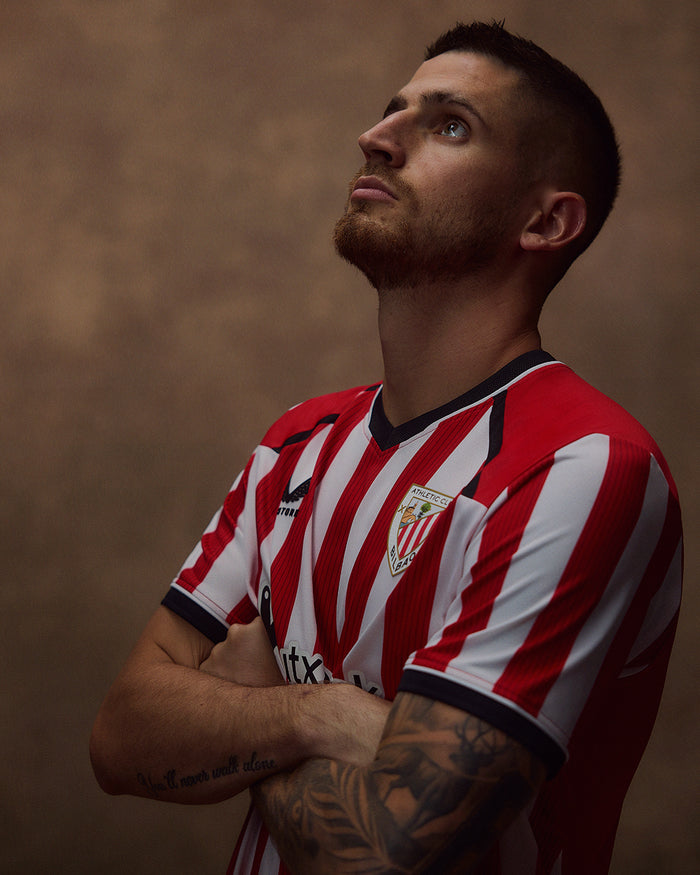 Portrait of a man wearing the red and white striped Home shirt with club crest on the chest