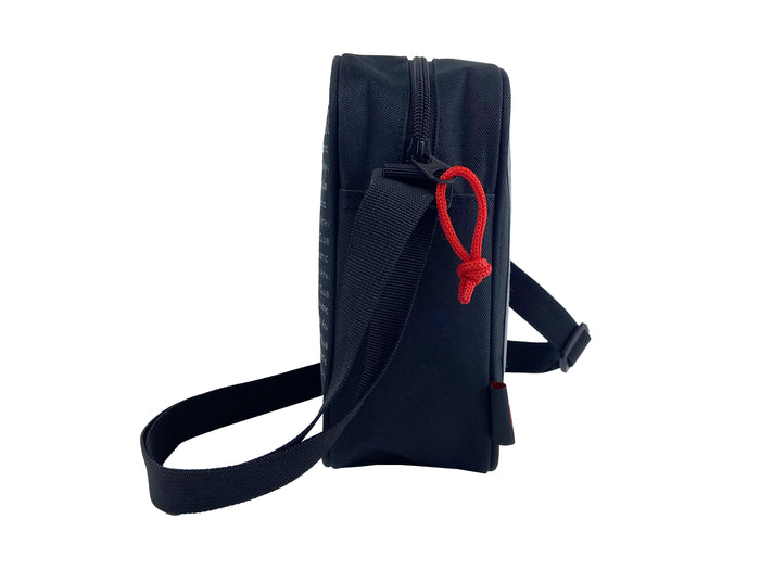 Side view of a navy shoulder bag showing a zipper and red paracord zipper pull with strap.