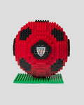 Red and black brick football puzzle sculpture on a green base with a club crest at the center