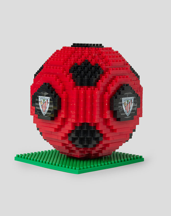 Angled side view of red brick football puzzle on a green base with crest decals on the sides