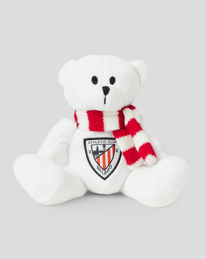 Osito de peluche blanco con bufanda a rayas roja y blanca.