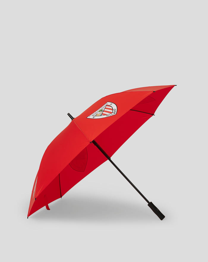 Red umbrella with Athletic Club Bilbao crest on the canopy, angled across a light gray backdrop.