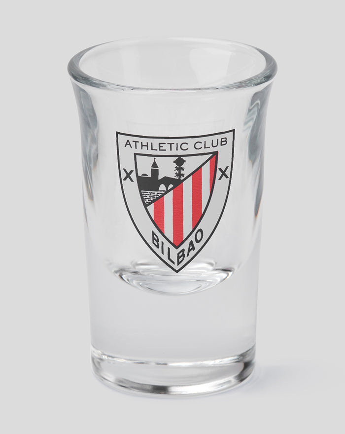 Close-up of a clear shot glass with the Athletic Club Bilbao crest