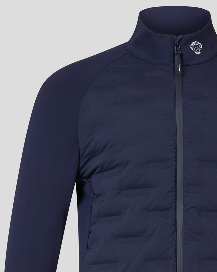 Close-up of navy hybrid jacket chest area showing crest badge near collar and front zipper