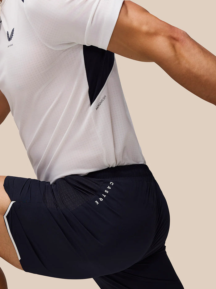 Navy Apex training shorts with subtle side panels and Castore branding, paired with a white performance tee