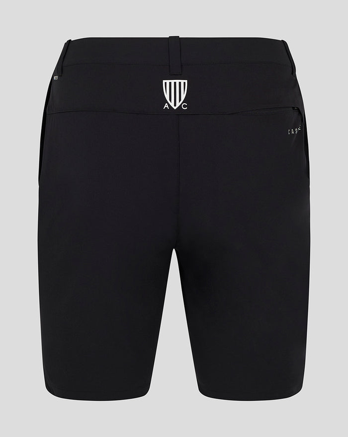 Back view of black golf shorts with a white crest logo centered on the waistband.