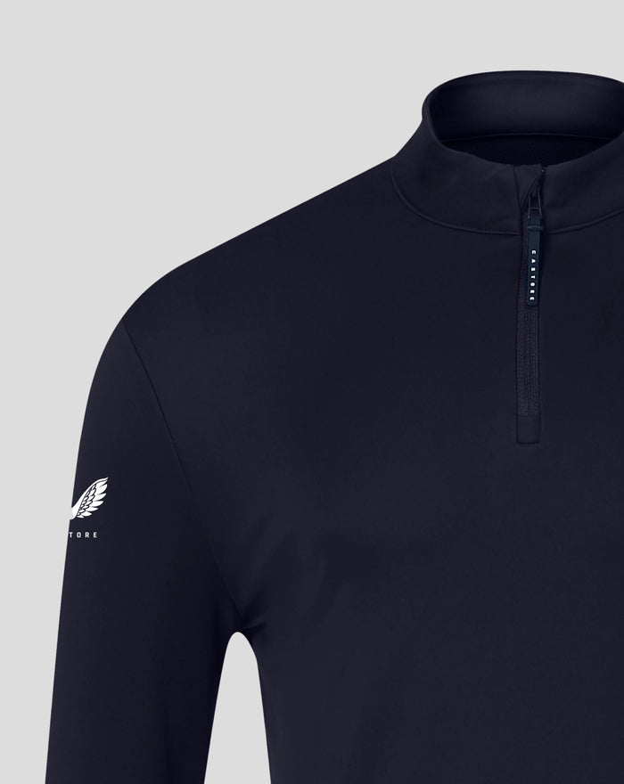 Navy quarter zip top with white crest visible on the lower left front