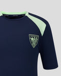 Detail of navy short sleeve tee with mint green shoulder panel and crest emblem on the front.