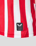 Lower hem of red and white striped home jersey showing Castore authentic product patch