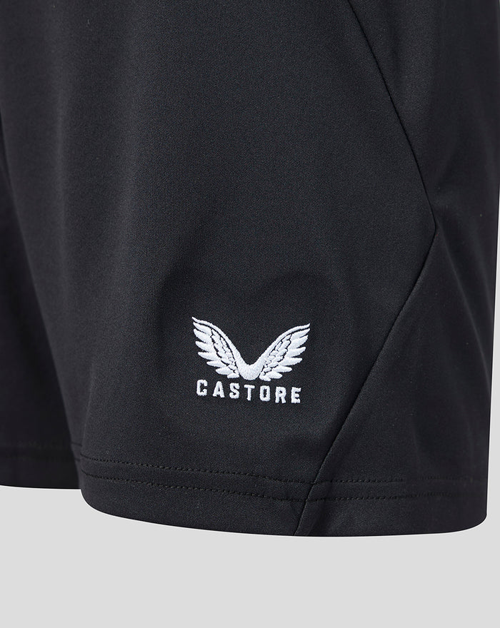 Close-up of white Castore logo with wings on black junior goalkeeper shorts.