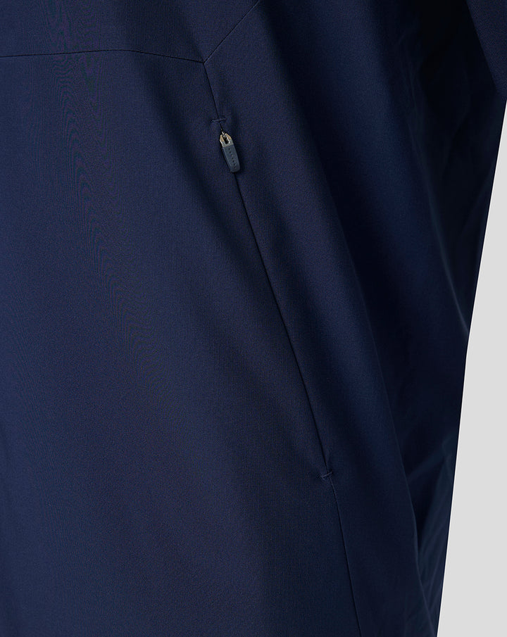 Detail of navy jacket side with vertical zipper pocket.