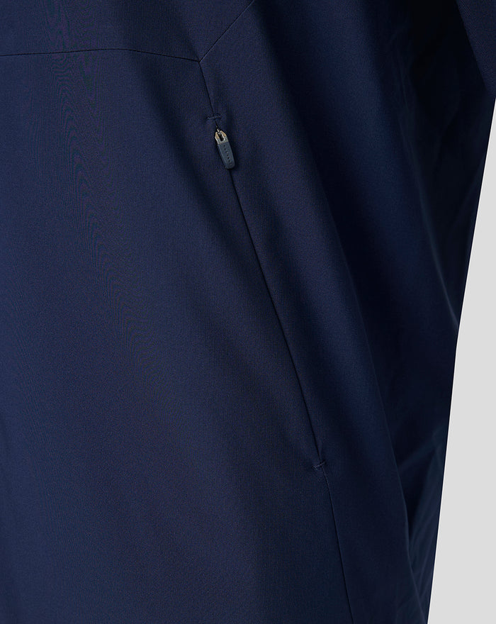 Detail of navy jacket side with vertical zipper pocket.