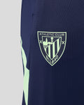 Athletic Club Bilbao shield logo on navy pant leg with mint green accent.