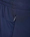 Close-up of zip pocket on navy performance shorts with visible stitching and waistband