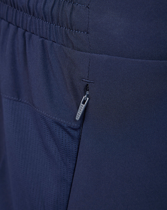 Close-up of navy shorts showing a zippered side pocket.