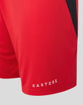 Close-up of red Away shorts hem with Castore branding and black side panel.