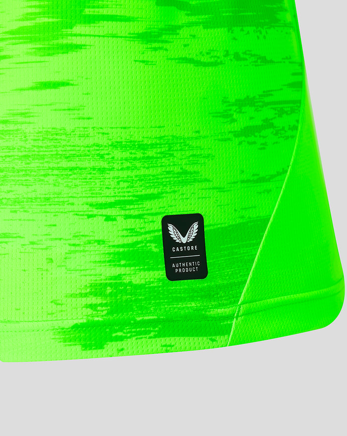Close up of neon green goalkeeper shirt hem with Castore Authentic Product patch.