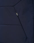 Close-up of navy gilet front zipper and vertical pocket zipper with pull tag.