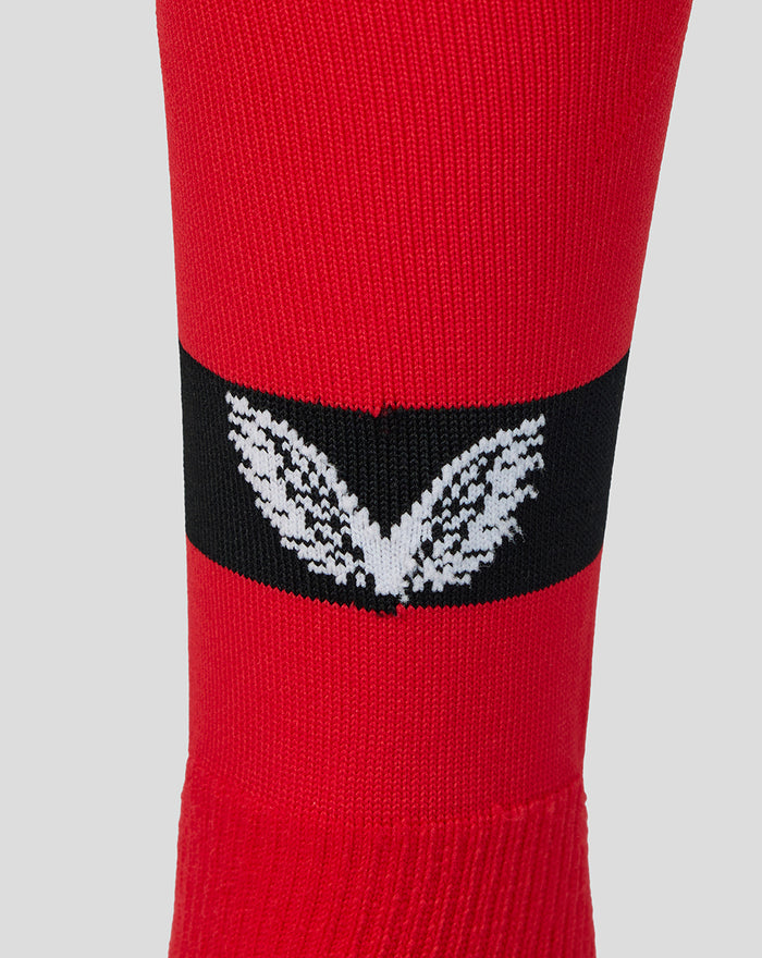 Close up of red Away Change sock for adults with a black band and white winged emblem