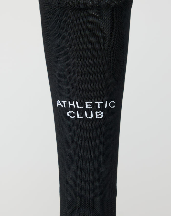 Close up of black Home goalkeeper sock with white Athletic Club lettering on the lower leg.