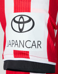 Close up of red and white striped home jersey showing JAPANCAR sponsor patch on the back