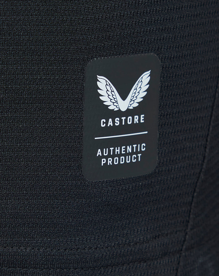 Close-up of black knit fabric with a Castore authentic product tag.