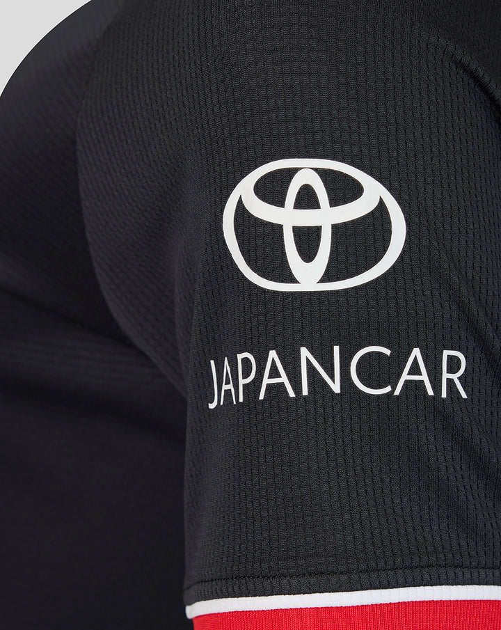 Back view of black away short sleeve shirt with red collar trim and a small neck patch at the upper back.