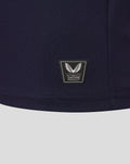 Navy knit fabric close up with Castore Authentic Product patch at the hem.
