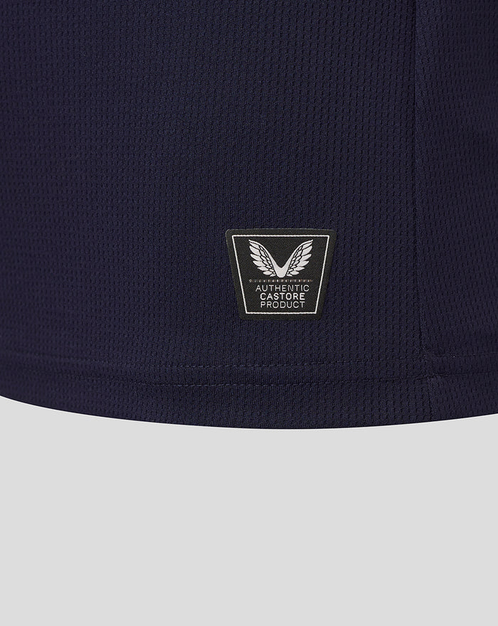 Navy knit fabric close up with Castore Authentic Product patch at the hem.