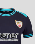 Close-up of navy Kosner Athletic Club away shirt showing turquoise collar and shoulder trim with Castore branding and crest on chest.