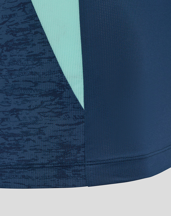 Detail of the hem and teal side panel on the navy Athletic Club tee with textured fabric.