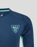 Close-up of women's navy Athletic Club training tee showing left chest crest and right chest Castore logo.