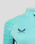 Front close-up of turquoise athletic club midlayer top with Castore logo, club crest, and patterned sleeves.