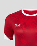 Close up of red athletic club home tee showing white collar trim and chest emblems Castore on right and Athletic Club crest on left