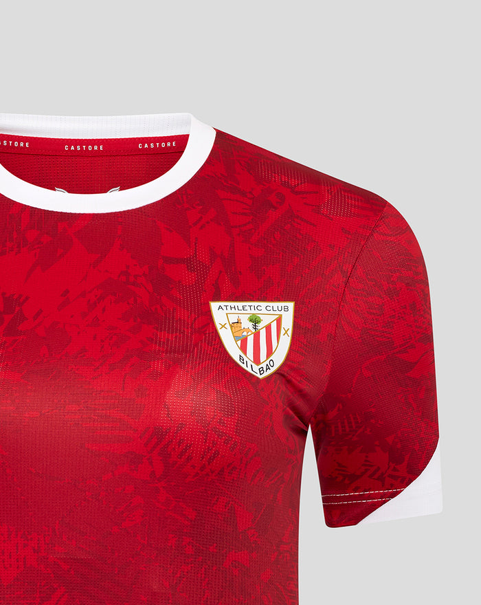 Red women's Athletic Club home tee with white collar features abstract print and Castore right chest and Club crest on left