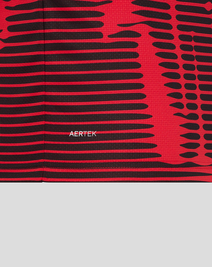 Hem level close up of the red and black Athletic Club shirt with a small AERTEK label