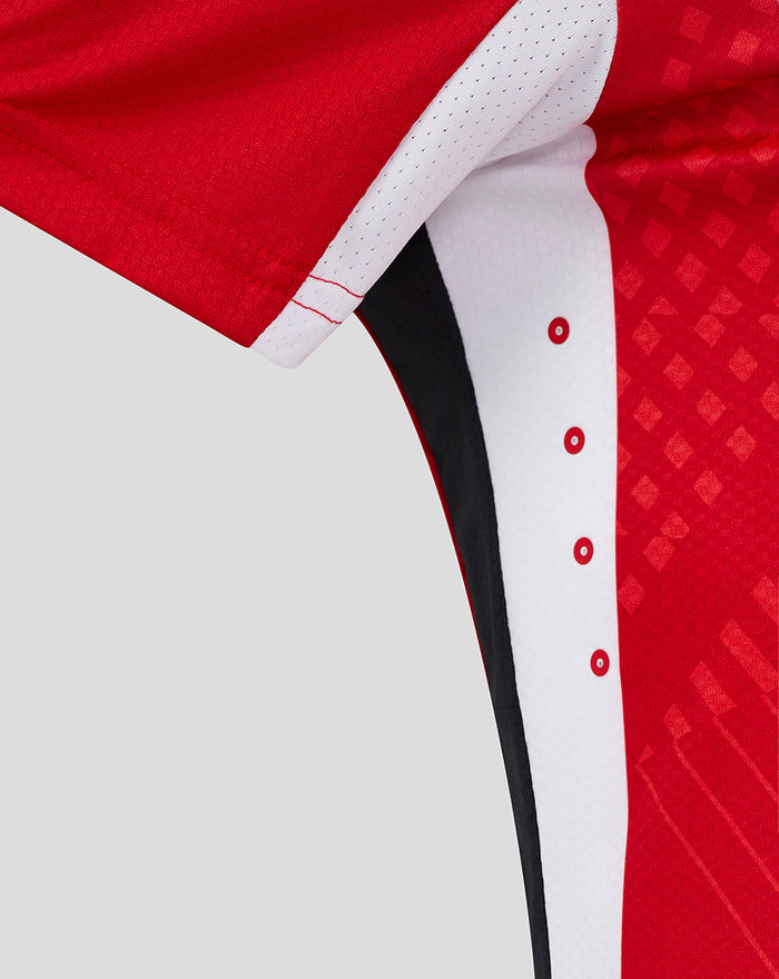 Close up of red women's home shirt sleeve with white perforated trim and side stripe.