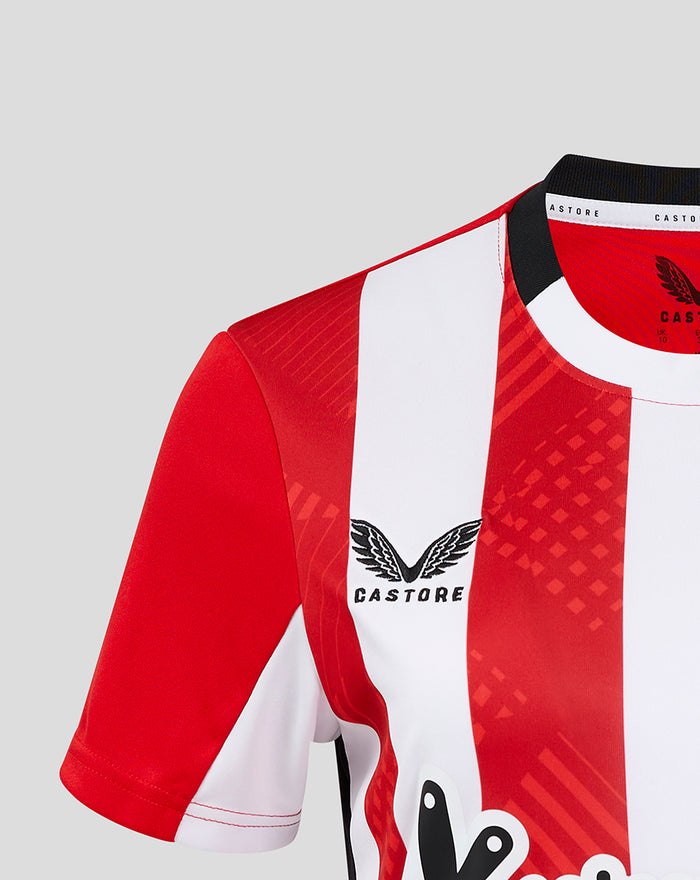 Close up of red and white striped women's home shirt showing club crest and Castore branding.