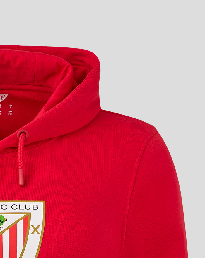 Red women's core hoodie close-up showing hood and partial crest logo on chest
