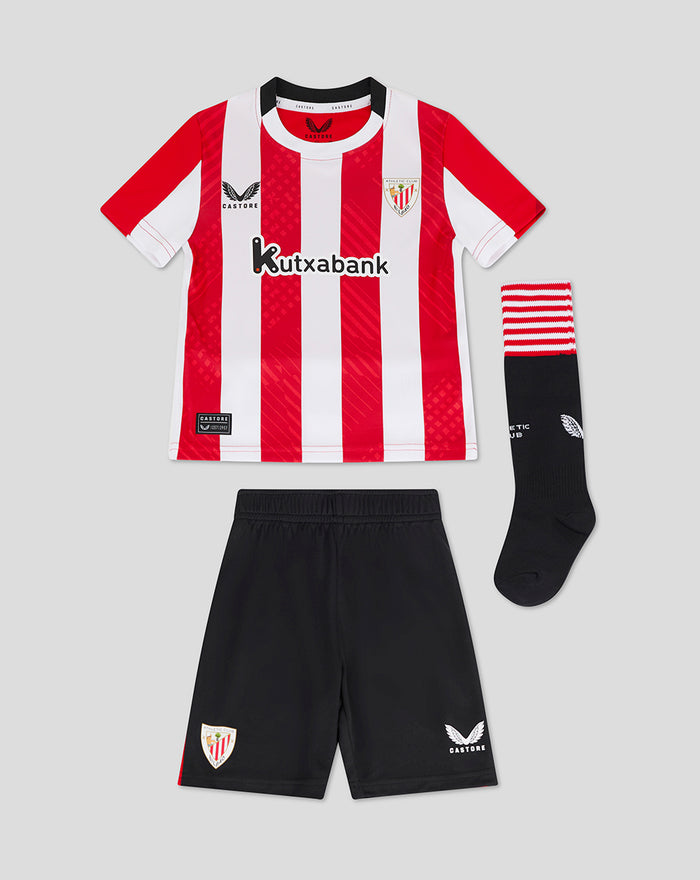 Infant athletic club kit with red white striped shirt black shorts and striped socks laid flat.
